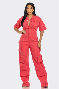 Retro Denim Cargo Jumpsuit Model wearing a vibrant coral utility jumpsuit featuring short sleeves, a button-up front, and multiple cargo pockets for a functional yet stylish look. The cinched waist and wide-leg design add a flattering and modern touch, perfect for casual outings or statement streetwear by Rêve Dorés